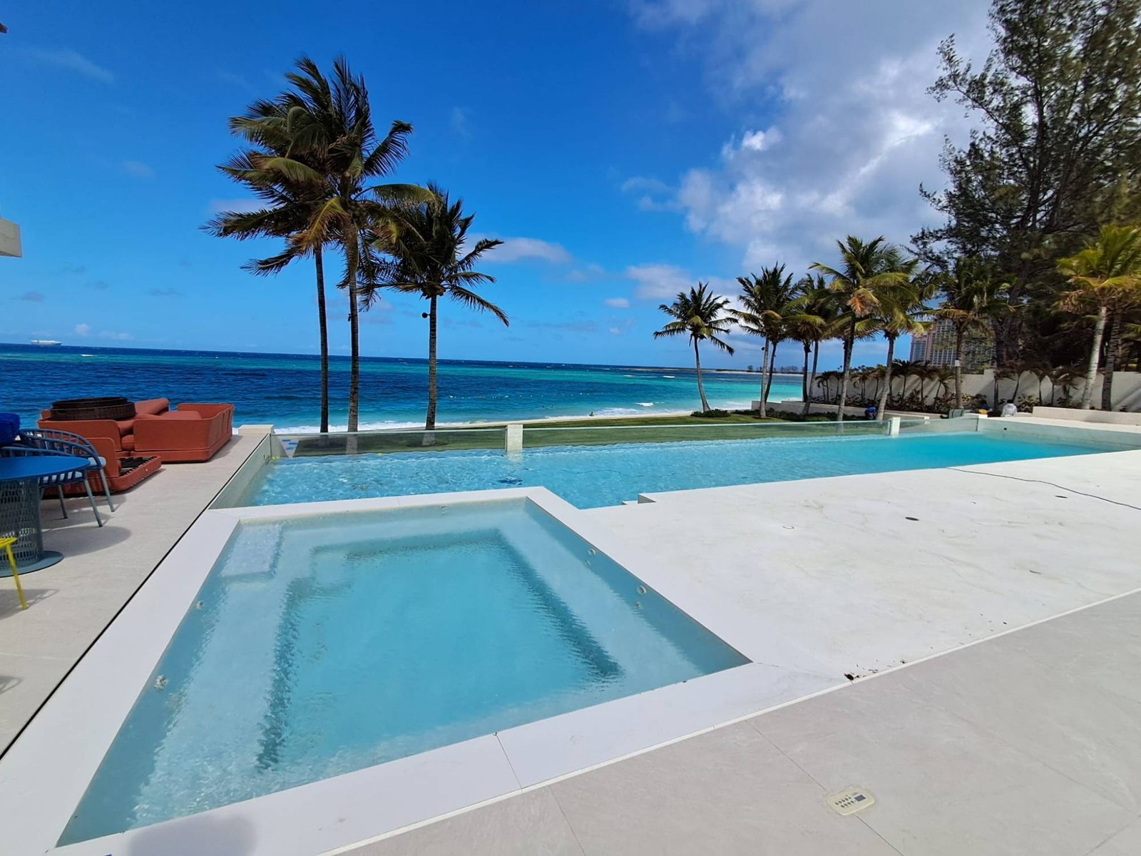 Beachfront infinity pool and spa with palm trees and ocean view