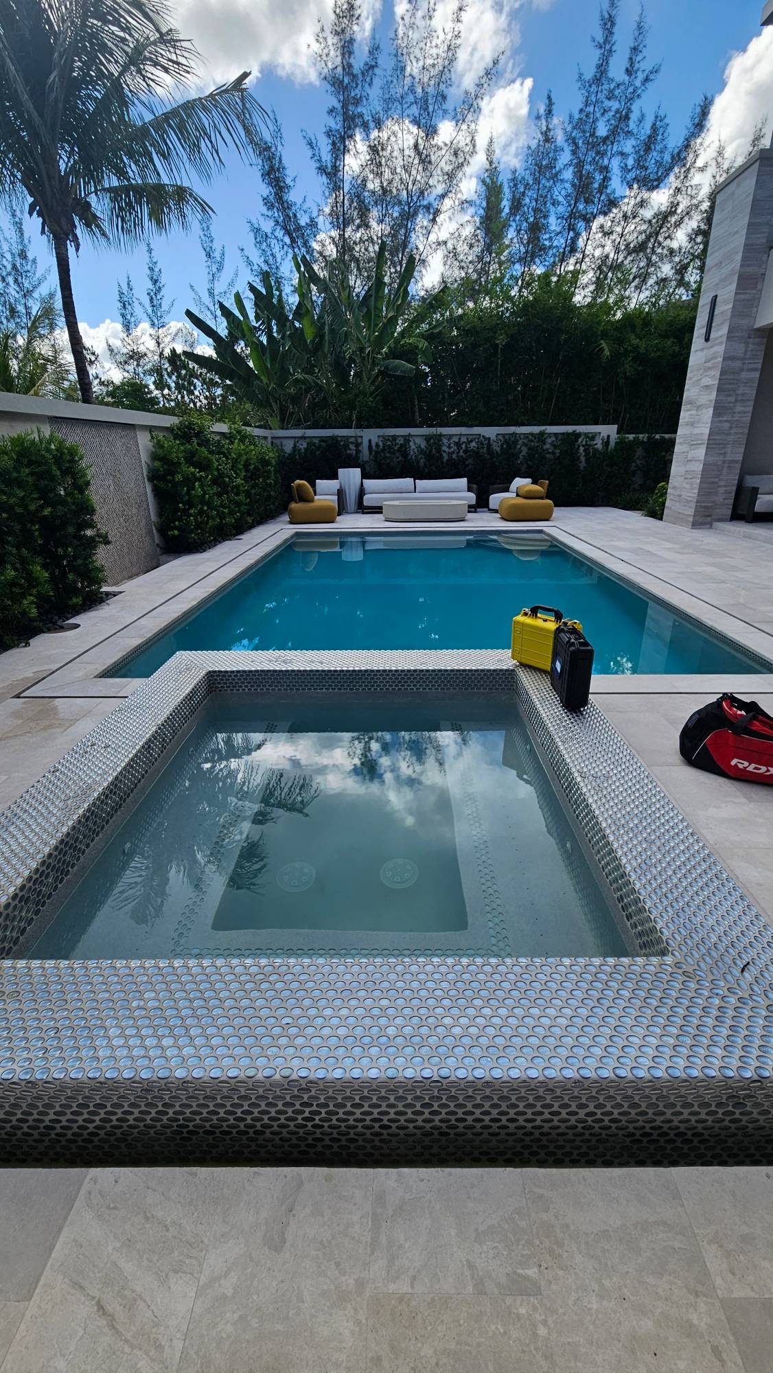 Leak detection equipment cases set up beside a tiled spa and pool